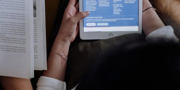 woman reading news using a tablet and another reading a book