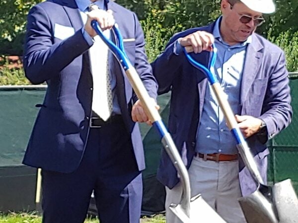Two men with hard hats and shovels