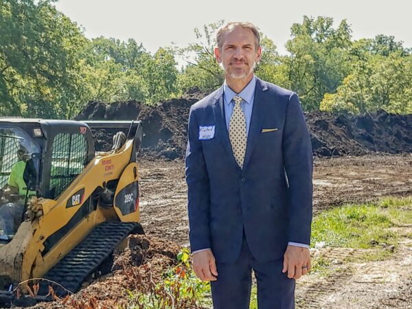 Man smiling in front of construction site