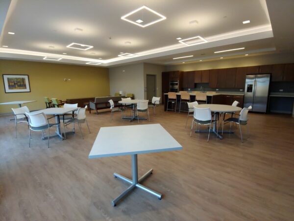 gathering space interior with tables and kitchen