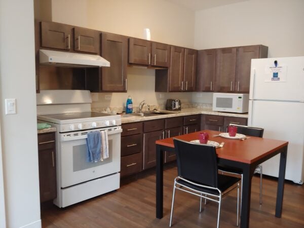 A kitchen with a white stove and small dining table.