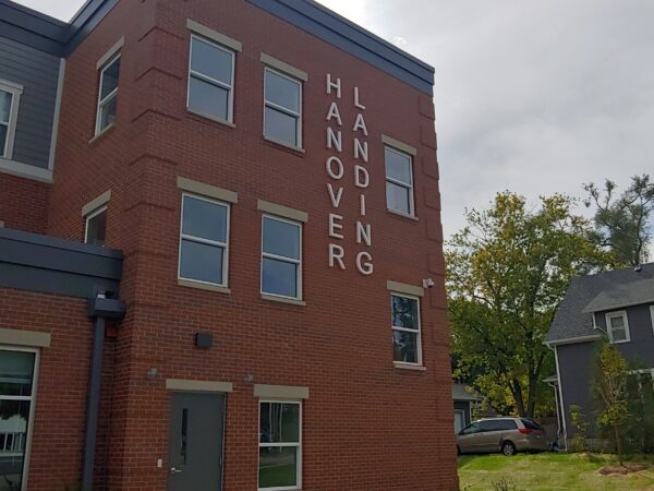 Three story red brick apartment building.