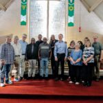 A group of black and white men and women pose in a church.