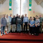 A group of black and white men and women pose in a church.
