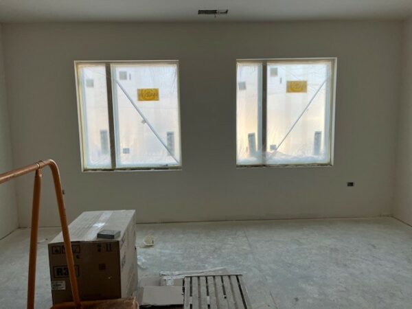 Inside a room under construction, new windows still have their stickers.