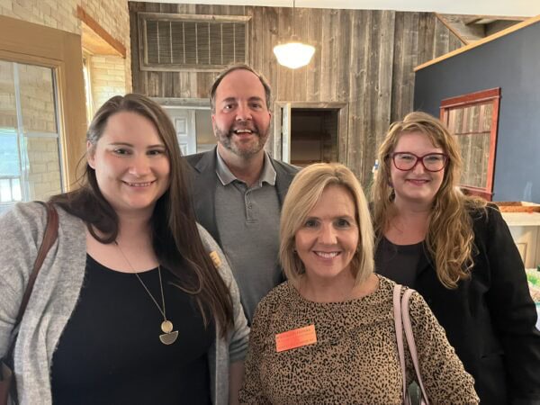A white man poses with three white women.