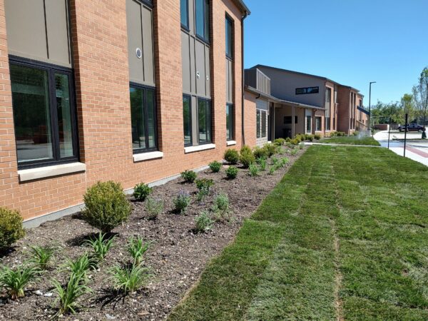 Two story apartment building with landscaping and green grass.