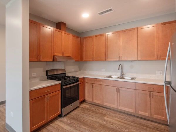 Kitchen with oak cabinets, a stove and a sink.