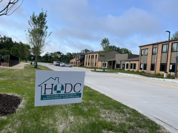 Two story apartment building. The HODC logo on a sign mounted on a yard stake in the foreground.