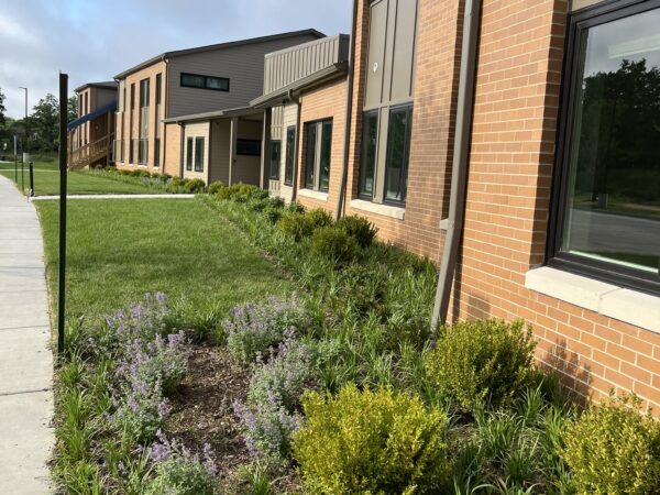 Two story apartment building with green grass and landscaping.