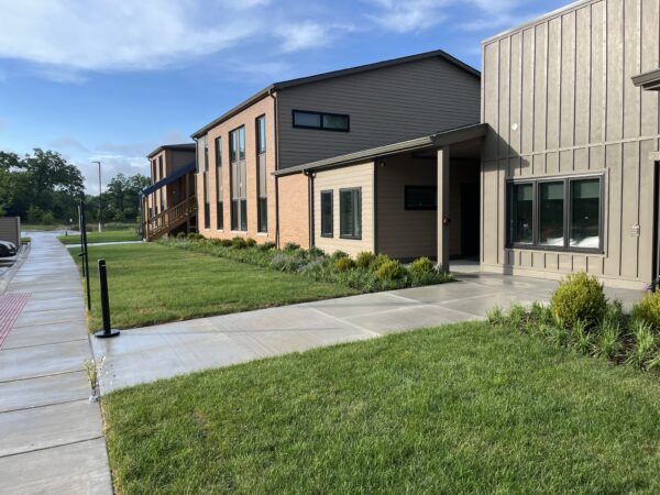 Two story apartment building with green grass.