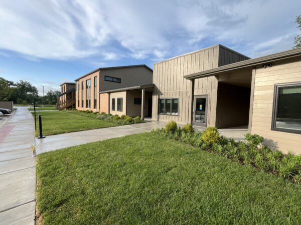 Two story apartment building with green grass.