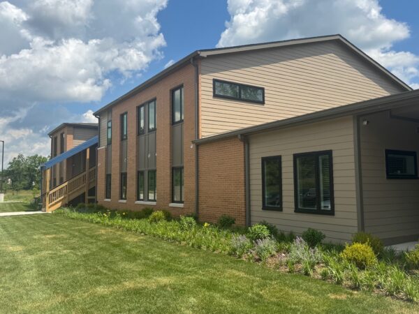 A two story apartment building with green grass and landscaping.