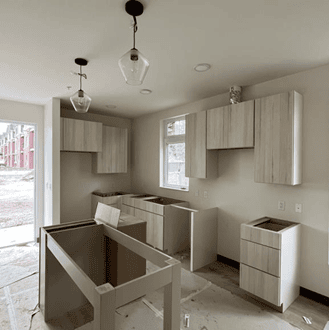 Interior of a kitchen with cabinets partially installed.