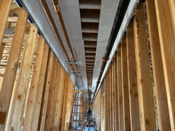 Interior of construction site with studs indicating a hallway.