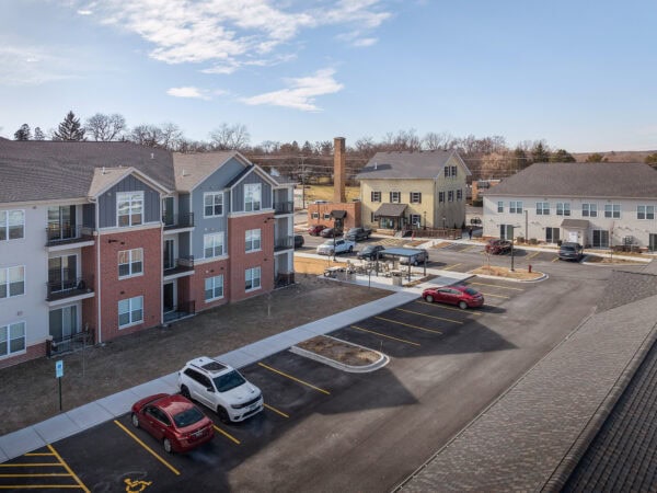 Apartment complex with parking lot and residential buildings in a suburban area.