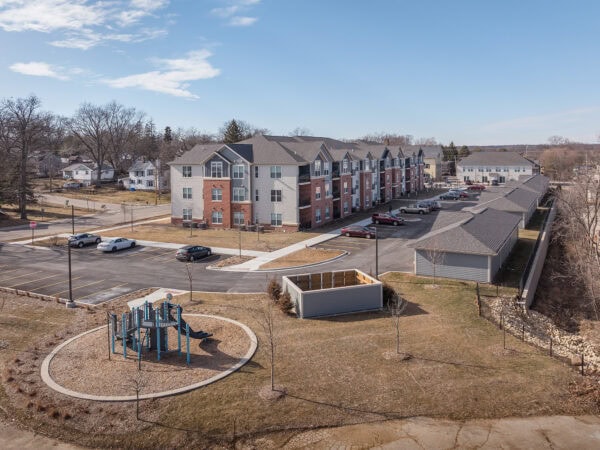 Apartment complex with playground and parking lot for residents.
