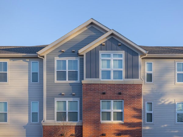 Modern apartment building with blue siding and brick accents.