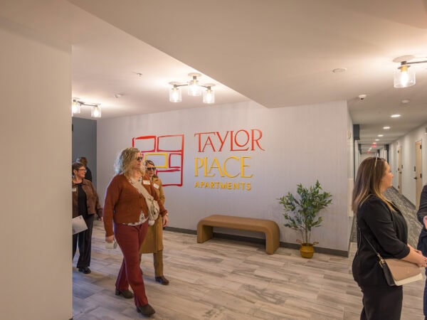 Modern apartment lobby at Taylor Place Apartments with residents and staff interacting.