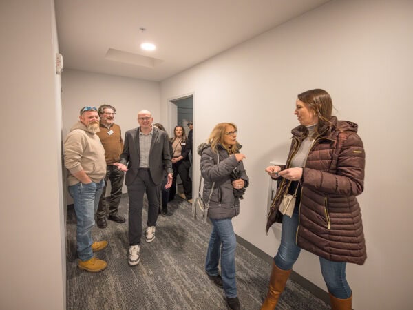 Group of people engaging in conversation in hallway at Taylor Place.