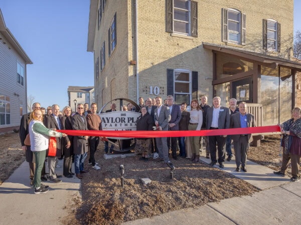 Community leaders at HODC building ribbon-cutting event in front of new housing.