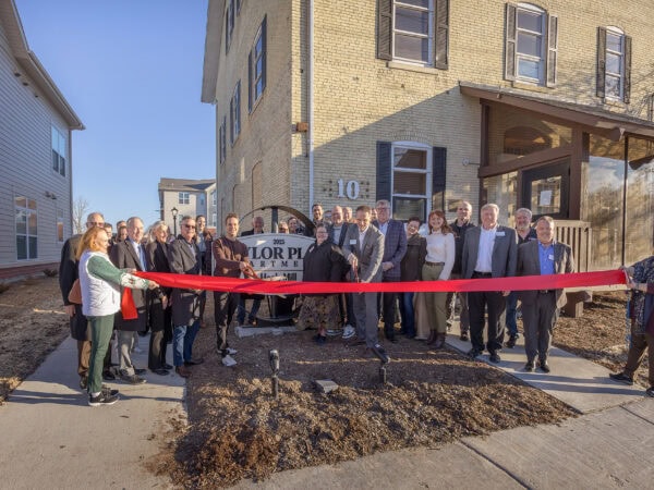 Community leaders and residents at HODC ribbon-cutting event outside new housing.