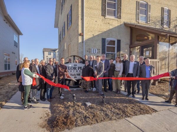 Community leaders and residents at HODC ribbon-cutting event outside new housing.