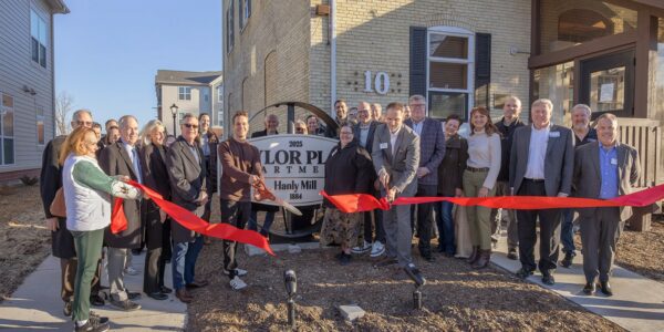 Community leaders and residents at HODC ribbon-cutting event outside new housing.