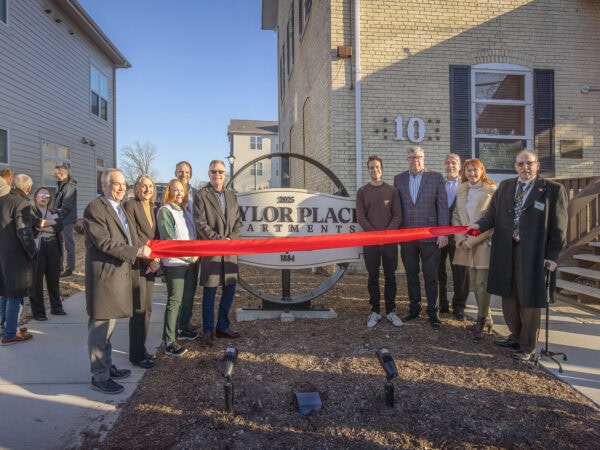 Group of people at HODC Tylor Place Apartments ribbon-cutting event.