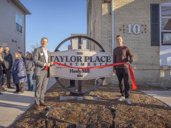 Unveiling of Taylor Place sign at HODC community event with attendees.
