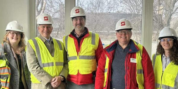 Group of professionals in safety vests and helmets indoors at HODC.