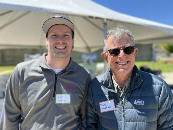 Two men pose together during an outdoor event.