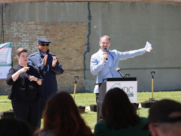 Community outdoor event organized by HODC with speakers and audience.