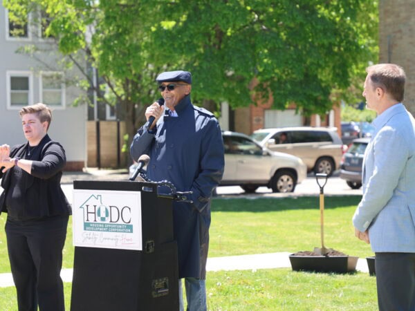 HODC community event with speaker and attendees outdoors.