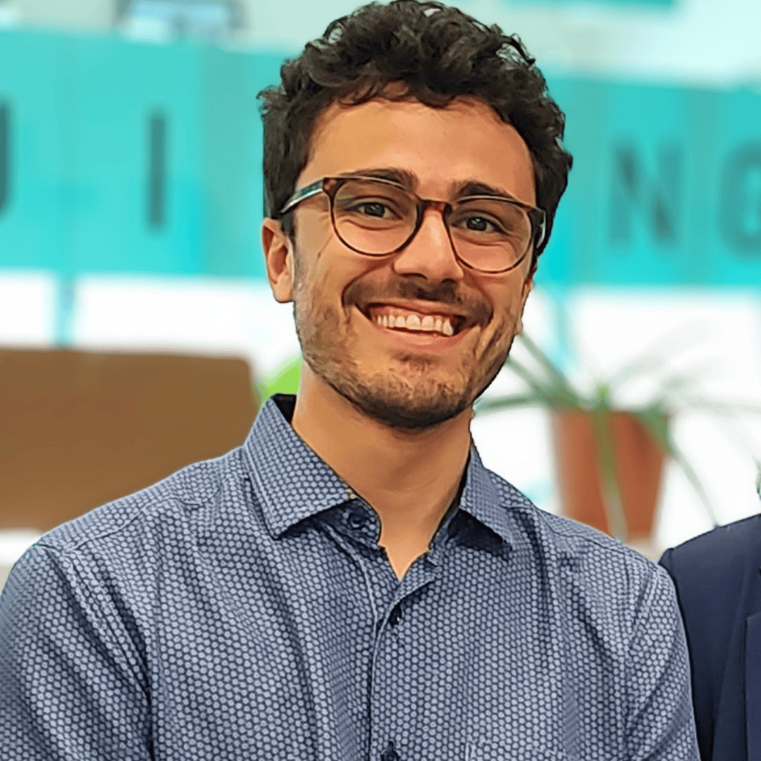 Smiling man with glasses in a blue shirt.